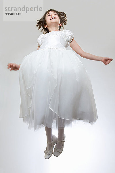 Mädchen in weißem Kleid  springend