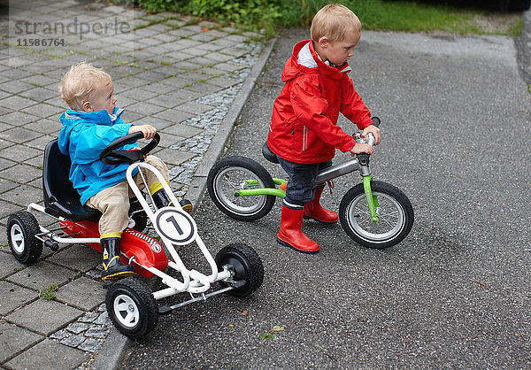 Kleinkinder Jungen fahren Fahrrad und Gokart