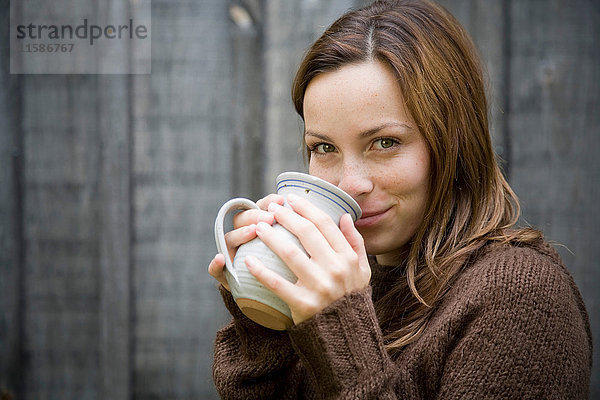 Frau trinkt aus Becher