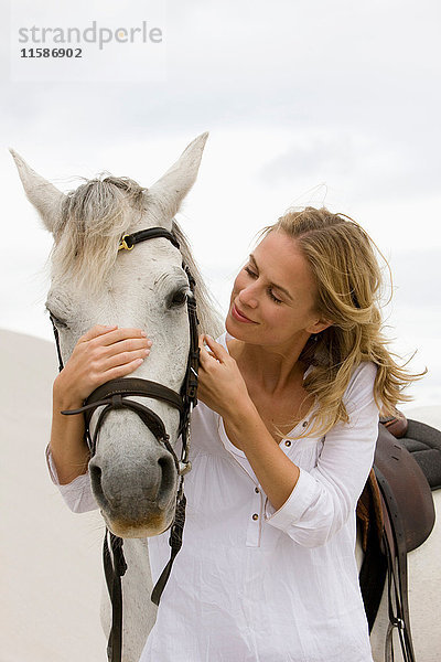 Frau mit Pferd am Strand