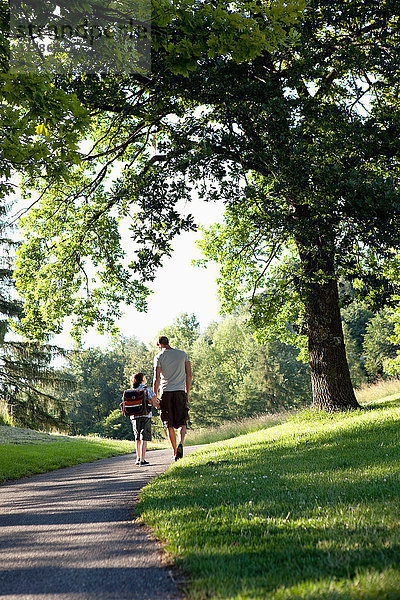 Vater und Sohn gehen im Park spazieren