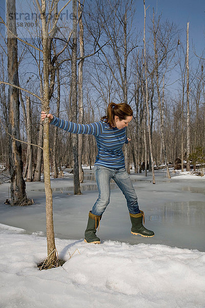 Frau testet Eis am Teich
