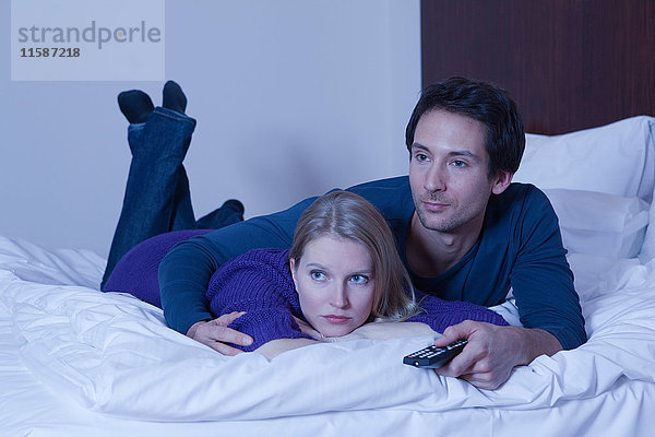 Paar im Bett beim Fernsehen