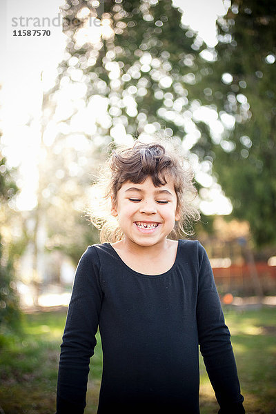 Junges Mädchen lächelt im Garten