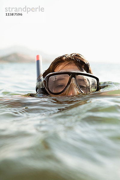 Frau mit Schnorchel im Wasser