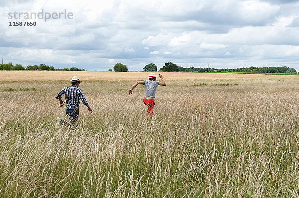 Männer laufen im Weizenfeld