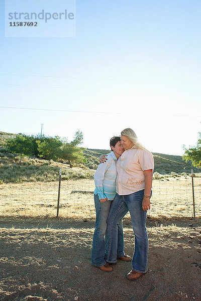 Reifes lesbisches Paar umarmt sich auf der Ranch