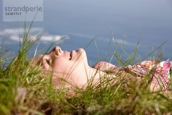 Junge Frau im Grasfeld liegend