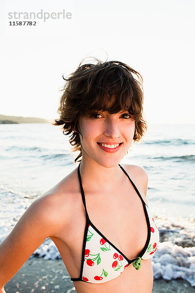 Lächelnde Frau im Bikini am Strand