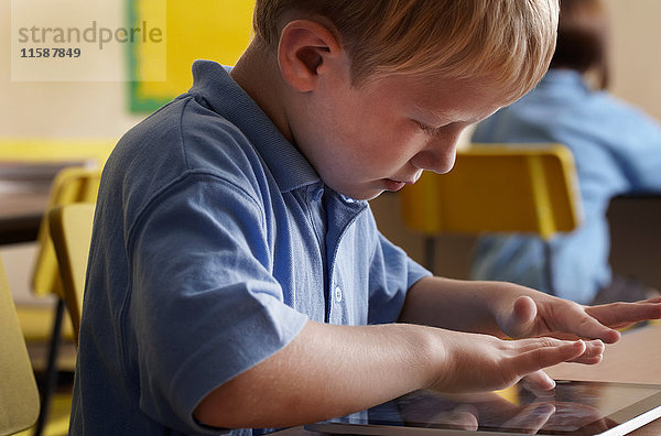 Schuljunge benutzt Touchscreen-Notebook im Klassenzimmer