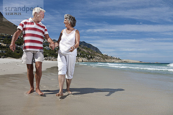 Älteres Paar beim gemeinsamen Strandspaziergang