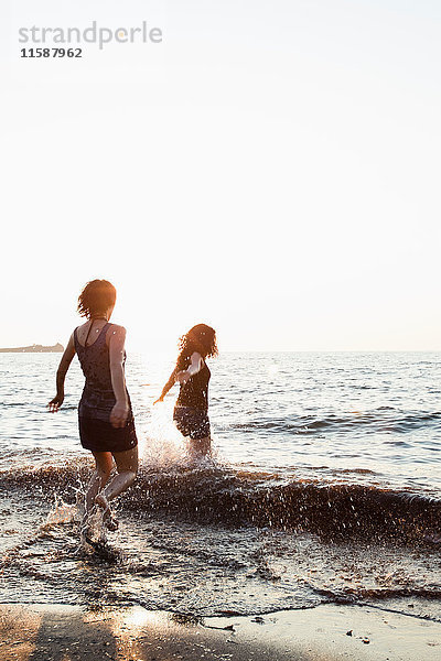 Frauen spielen in Wellen am Strand