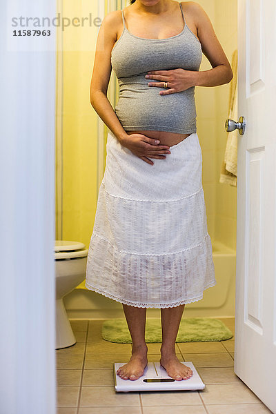 Schwangere Frau wiegt sich selbst