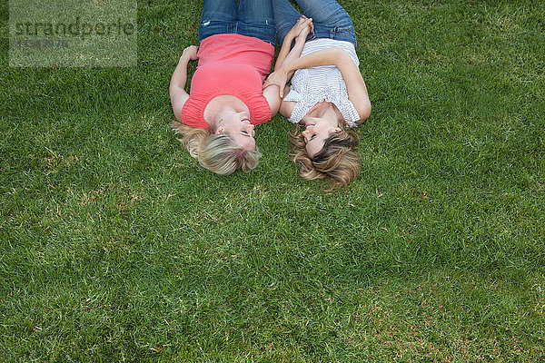 Junges lesbisches Paar liegt zusammen auf Gras
