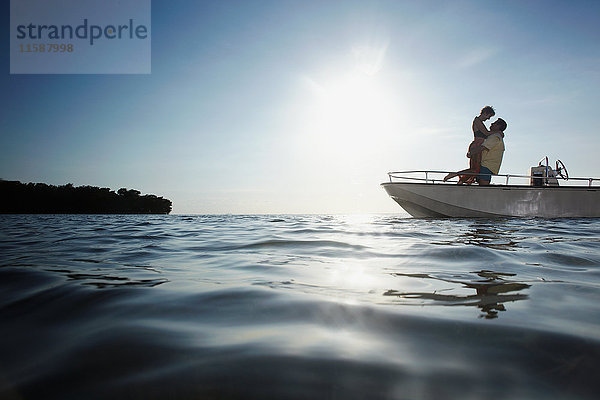 Älteres Ehepaar umarmt sich auf einem Motorboot