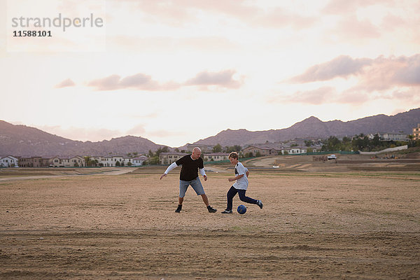 Mann und Junge spielen Fussball