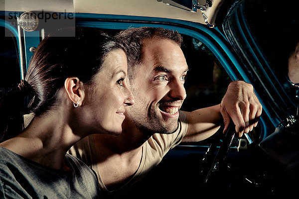 Lächelndes Paar fährt nachts Auto