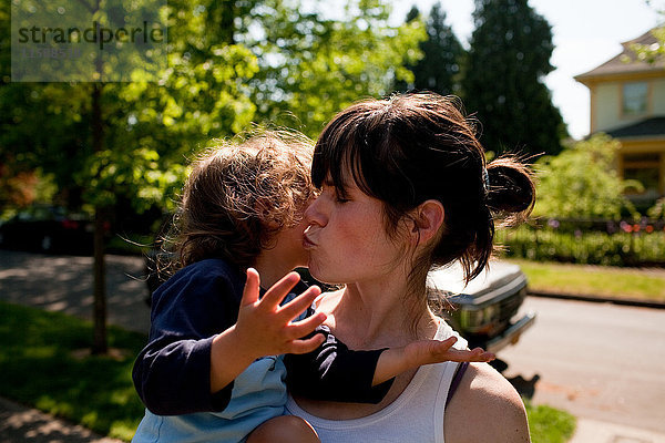 Mutter küsst Kleinkind-Tochter