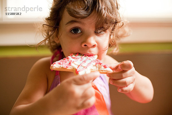 Mädchen isst sternförmigen Keks