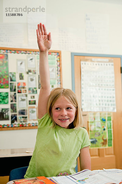 Grundschüler hebt die Hand