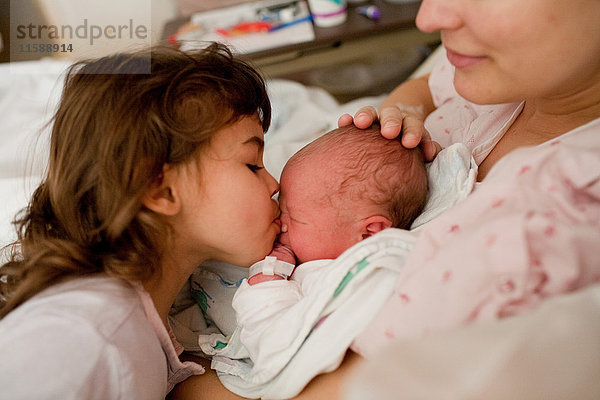 Mutter mit neugeborenem Jungen und Tochter im Krankenhausbett