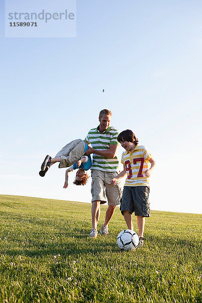 Vater und Jungen beim Fussballspielen