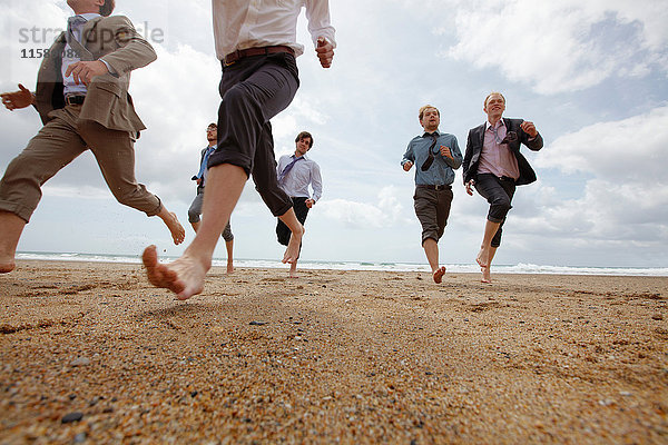 Geschäftsleute laufen am Strand