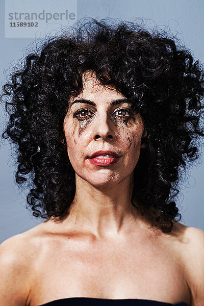 Frau weint mit verschmiertem Make-up im Gesicht