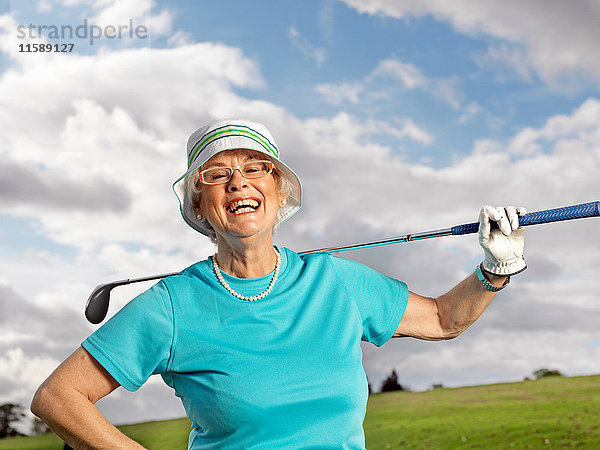 Reife Dame beim Golfspielen