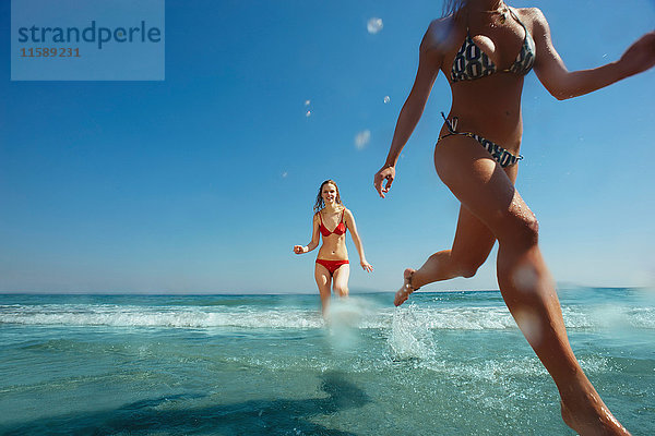 Zwei Mädchen laufen aus dem Meer