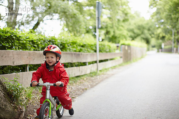 Lächelnder Junge fährt Fahrrad im Freien