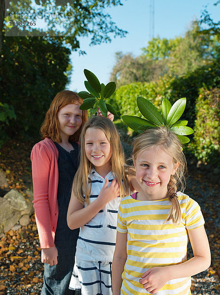 Junge Mädchen halten Blätter  lächelnd  Porträt