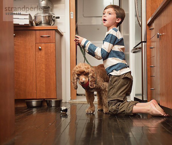 Junge mit Hundeleine in der Küche