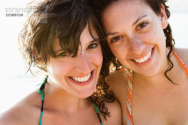 Frauen in Bikinis lächeln zusammen