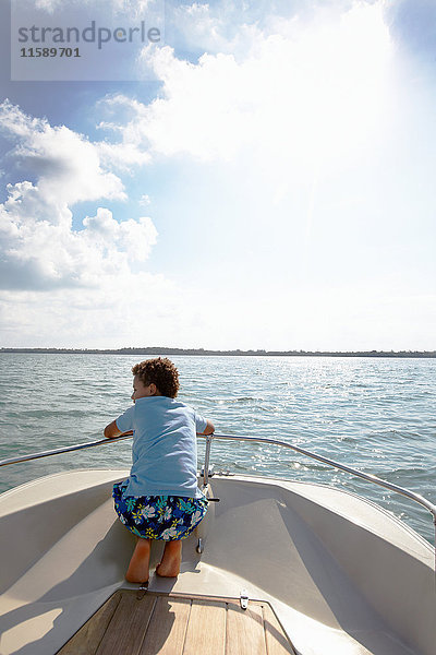 Junge schaut vom Motorboot aus auf die Aussicht