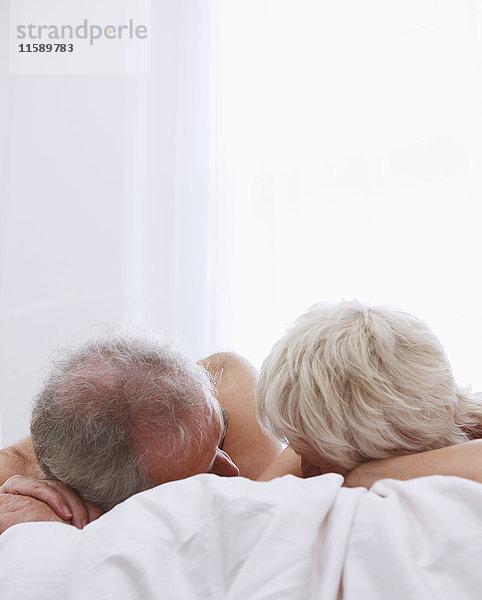 Seniorenpaar entspannt im Bett