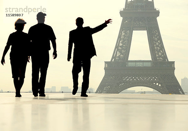 Silhouette von Menschen  die vor dem Eiffelturm spazieren