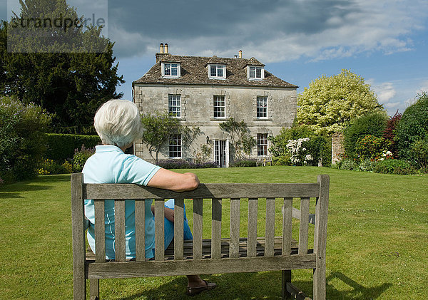 Ältere Frau im Garten sitzend