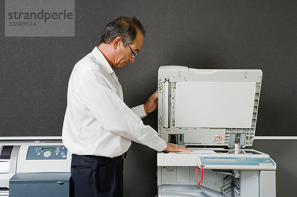 Mann beim Fotokopieren im Büro