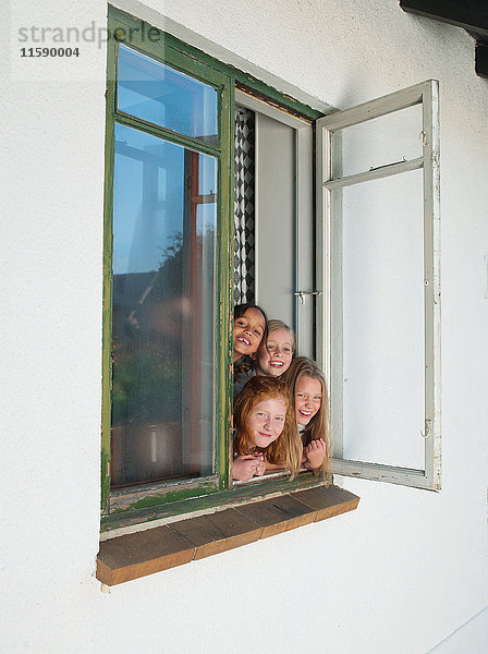 Mädchen schauen durch offenes Fenster  Portrait