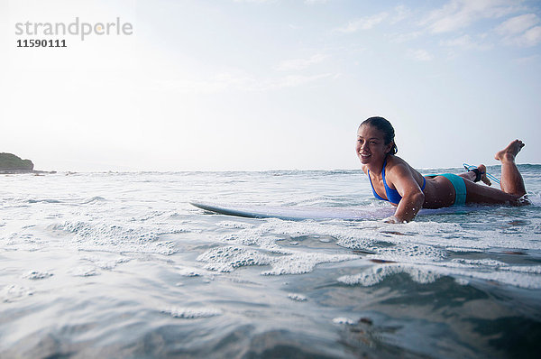 Surfer paddeln in ruhigem Wasser