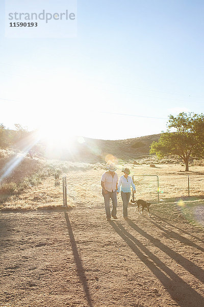 Ein reifes lesbisches Paar geht bei Sonnenuntergang durch die Ranch