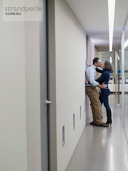 Küssende Paare in einem Bürokorridor