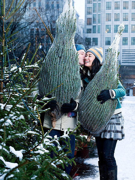 Ein Paar kauft Weihnachtsbäume