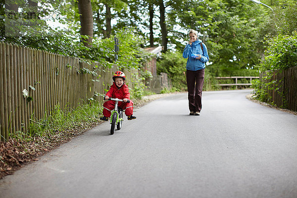 Mutter beobachtet Sohn beim Fahrradfahren