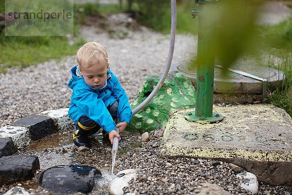 Kleinkind Junge spielt mit Schlauch