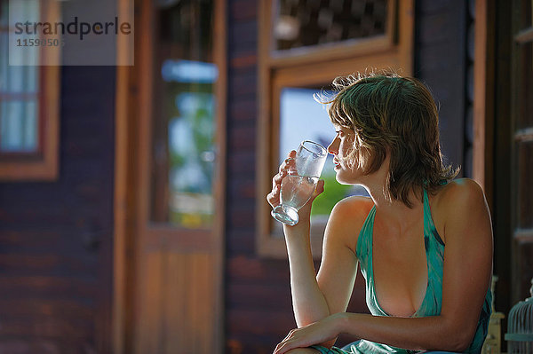 Junge Frau hält Wasserglas