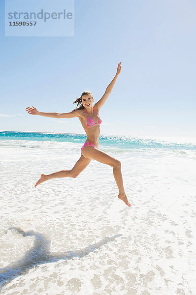 Ein Mädchen springt auf den Strand