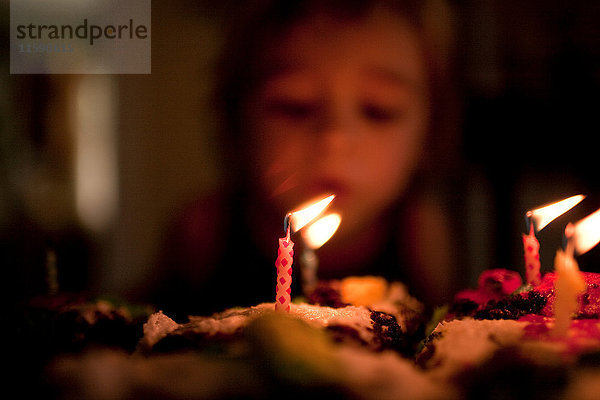 3 Jahre alter Junge bläst Kerzen auf Geburtstagskuchen aus