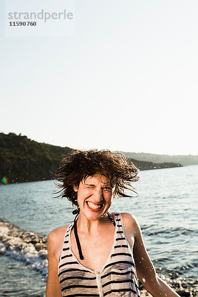 Lächelnde Frau spielt am Strand